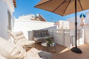 An outdoor seating area with a sofa, armchairs, and a small table, featuring a potted plant. - Casa da Bica T2 250m Old Town Beach (Albufeira)