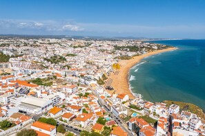 A coastal cityscape with a beach, residential buildings, and a clear sky. - Apartamento T1 Vistamar Centro Hist Rico Albufeira (Albufeira)