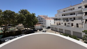 A residential area with white buildings, a paved courtyard, and parked cars. - Central Town 2-bedroom Classy Apartment Albufeira (Albufeira)