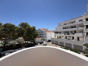 A residential area with white buildings, a paved courtyard, and parked cars. - Central Town 2-bedroom Classy Apartment Albufeira (Albufeira)