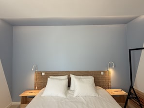 A bedroom with a bed, two bedside tables, a headboard with a woven pattern, and wall-mounted reading lights. - Central Town Classy T2 by Agarve Lodging (Albufeira)