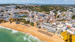 A coastal town with a beach, buildings, and a rocky cliff. - Geneve Old Town T3 Apartment (Albufeira)