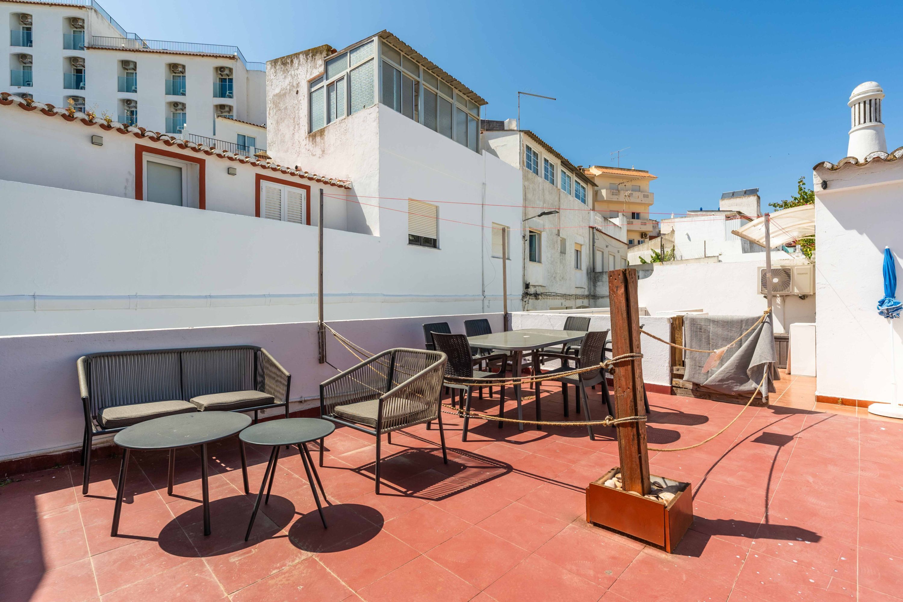 A rooftop terrace with outdoor seating, including tables and chairs, and a fire pit.