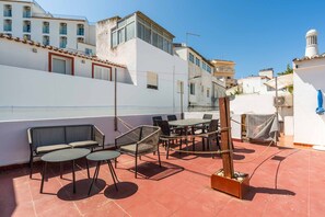 A rooftop terrace with outdoor seating, including tables and chairs, and a fire pit. - Geneve Old Town T3 Apartment (Albufeira)