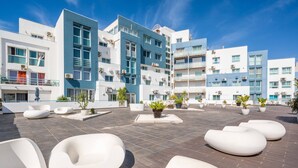 Terraço no telhado com mobiliário de exterior moderno e plantas em vasos.