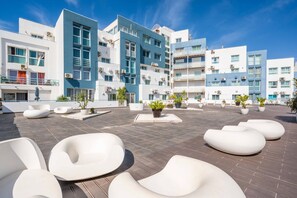 Eine Dachterrasse mit moderner Außenmöblierung und Topfpflanzen.