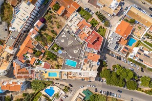 An aerial view of a residential area with multiple buildings, roads, and a swimming pool. - Old Town Bayview T1 w Pool - 350m to Beach (Albufeira)