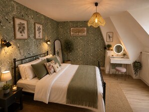 Ein Schlafzimmer mit einem Bett, Nachttischlampen, einem Schreibtisch mit Spiegel und einer Pendelleuchte.