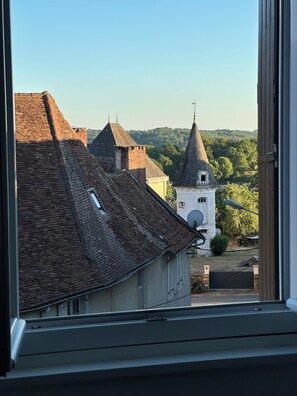 Blick auf Gebäude mit steilen Dächern und eine Kirche mit einem spitzen Turm.