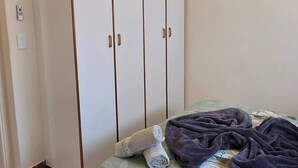 Ein Schlafzimmer mit einem Bett, einem Kleiderschrank und einer Deckenleuchte.