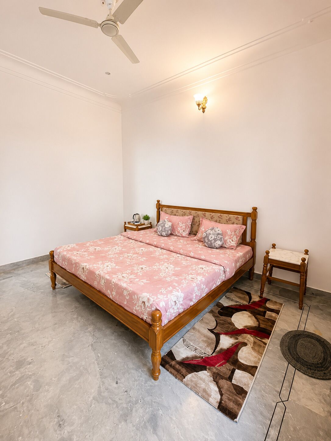 A bedroom with a bed, a nightstand, a lamp, and a ceiling fan.