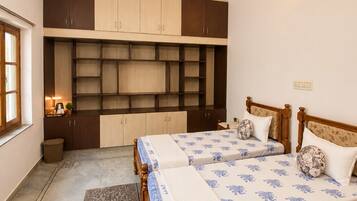 A bedroom with a double bed, built-in shelving, a ceiling fan, and a rug.
