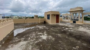A rooftop with a view of the city, a small building with a door, and a decorative structure. - 3BHK Homestay in Udaipur, Lake View Private Terrace & Parking (Udaipur)