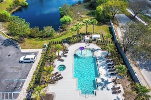 An aerial view of a resort with a swimming pool, lounge chairs, and a parking area. - Villa Domani 4BR - Private Pool - Near Disney (Davenport)