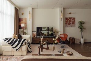 A modern living room with a sofa, coffee table, TV, and decorative items. - Saigon Cozy Home  (Ho Chi Minh City)