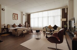 A modern hotel room with a bed, sofa, and a dining area. - Saigon Cozy Home  (Ho Chi Minh City)