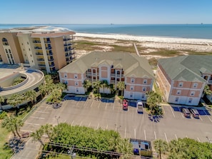 A multi-story hotel with a parking lot, a beach view, and a roundabout. - Side by Side Beach Condos | Sleeps 18, Pools + Beach Access (Dauphin Island)