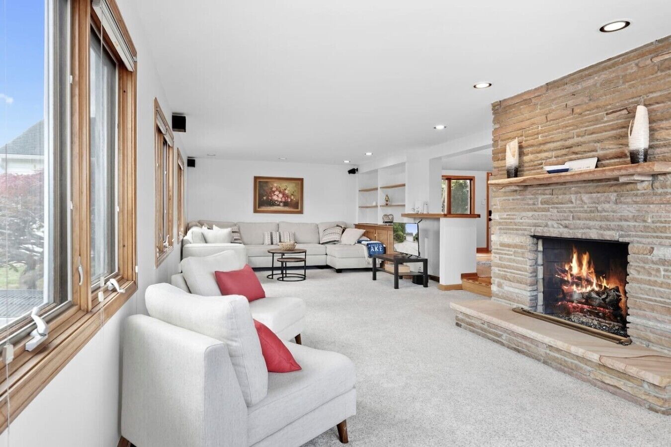 A modern living room with a fireplace, a sofa set, and a dining area.
