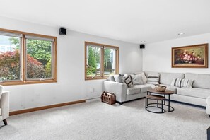 A living room with a grey sofa, a coffee table, and a painting on the wall.