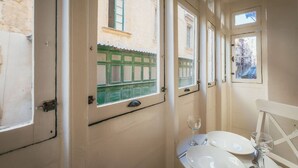 A narrow corridor with doors leading to rooms, each with a window. - Casa Due Balli 400-year Historic Valletta House (Valletta)