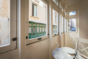 A narrow corridor with doors leading to rooms, each with a window. - Casa Due Balli 400-year Historic Valletta House (Valletta)
