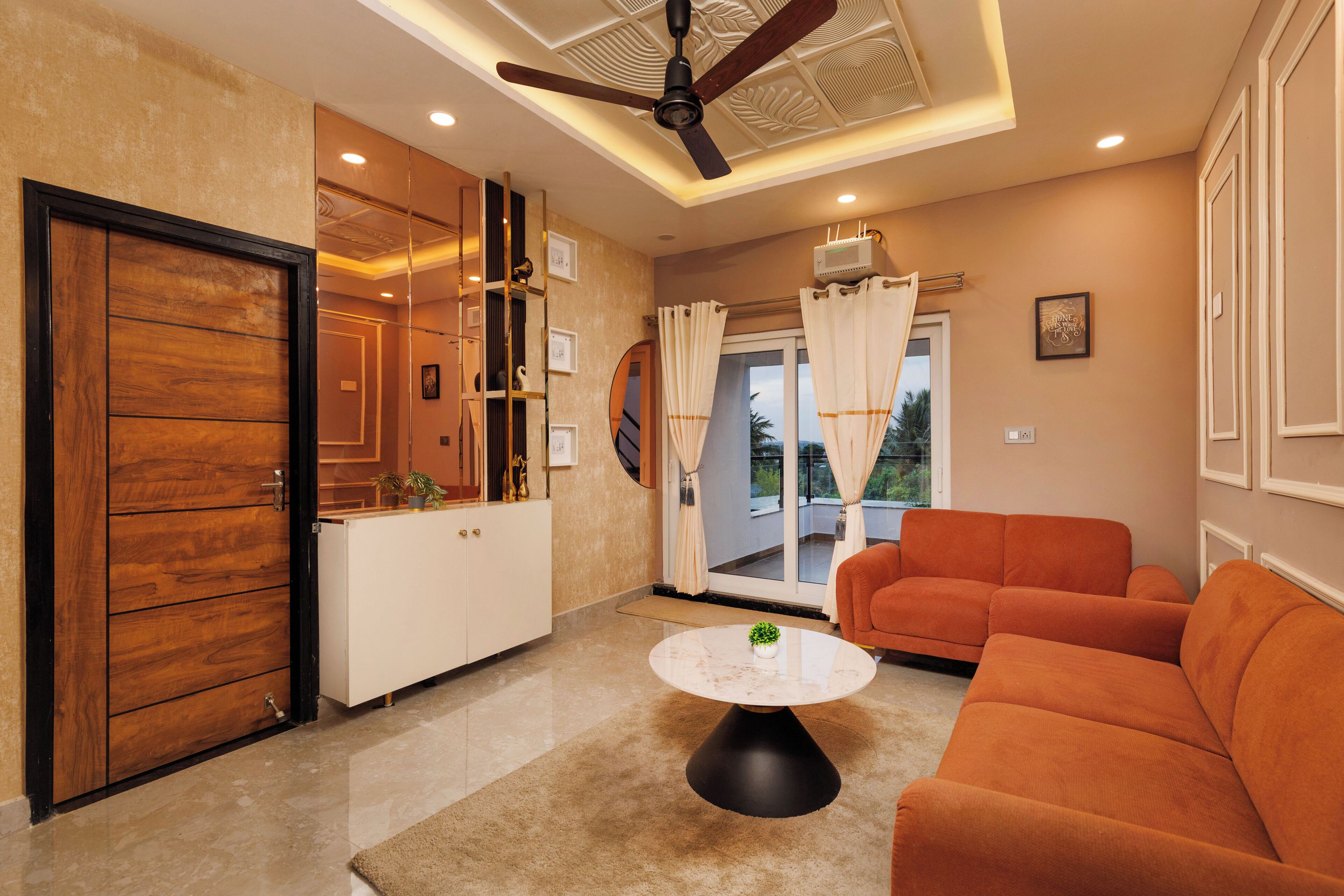 A modern living room with a sofa, a coffee table, and a ceiling fan.
