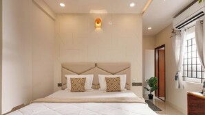 Une chambre à coucher moderne avec un grand lit, une tête de lit ornée d’un motif géométrique et une petite plante en pot.