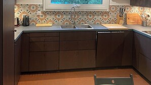 Uma cozinha moderna com janela integrada, pia e bancada.