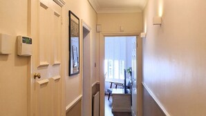 A hallway with a door on the left, a radiator on the right, and a window at the end. - Beautiful and spacious 2 Double Bed, 2 Bath Garden Flat, Ealing, London, W5 (London)