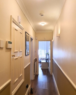 A hallway with a door on the left, a radiator on the right, and a window at the end. - Beautiful and spacious 2 Double Bed, 2 Bath Garden Flat, Ealing, London, W5 (London)