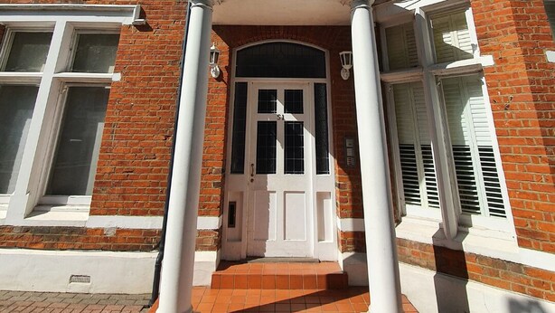 A two-story brick building with a white entrance and columns, featuring a number '51' above the door. - Beautiful and spacious 2 Double Bed, 2 Bath Garden Flat, Ealing, London, W5 (London)