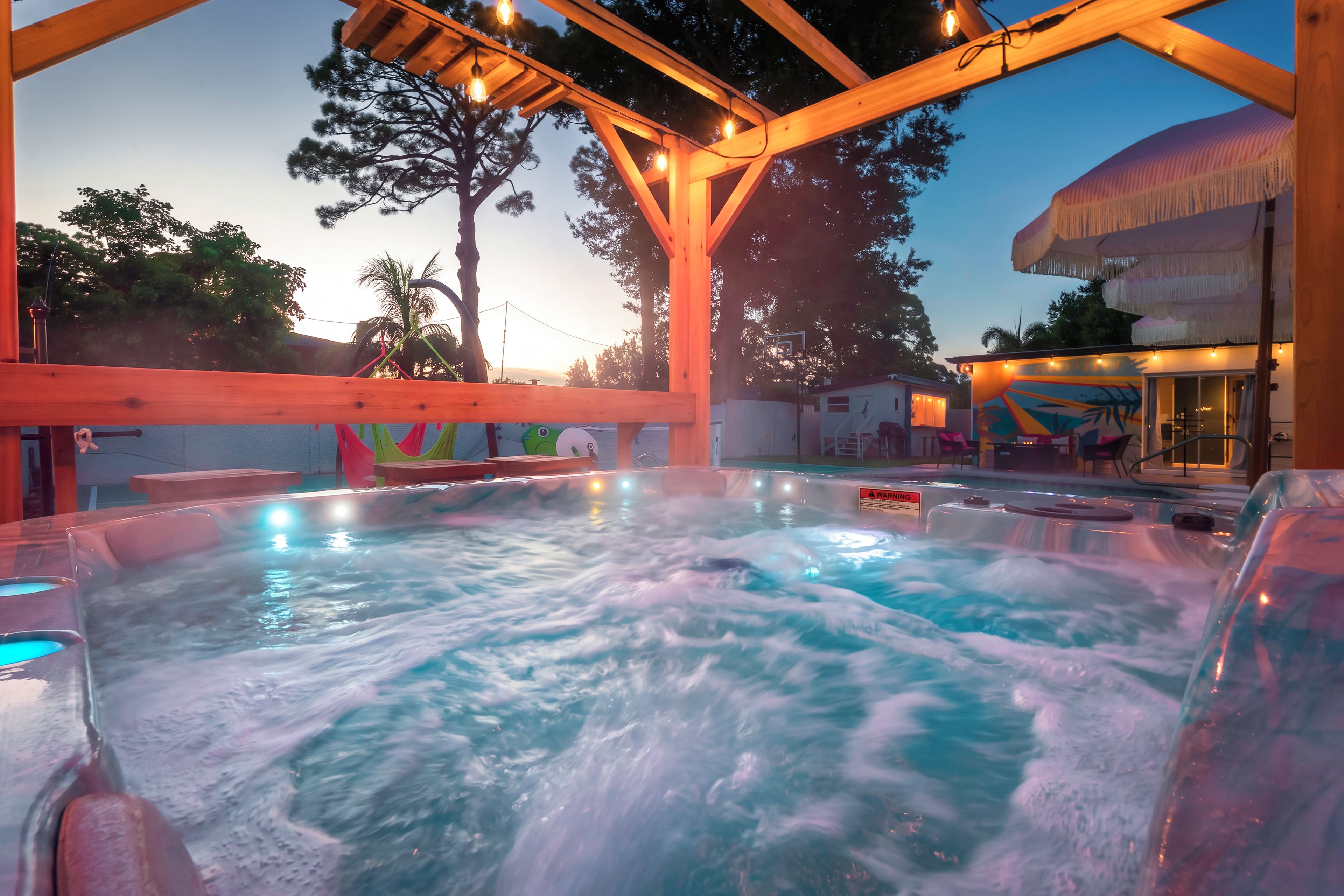 Zona de hidromasaje con vigas de madera en el techo y entorno junto a la piscina.