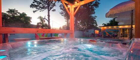 Zona de hidromasaje con vigas de madera en el techo y entorno junto a la piscina.