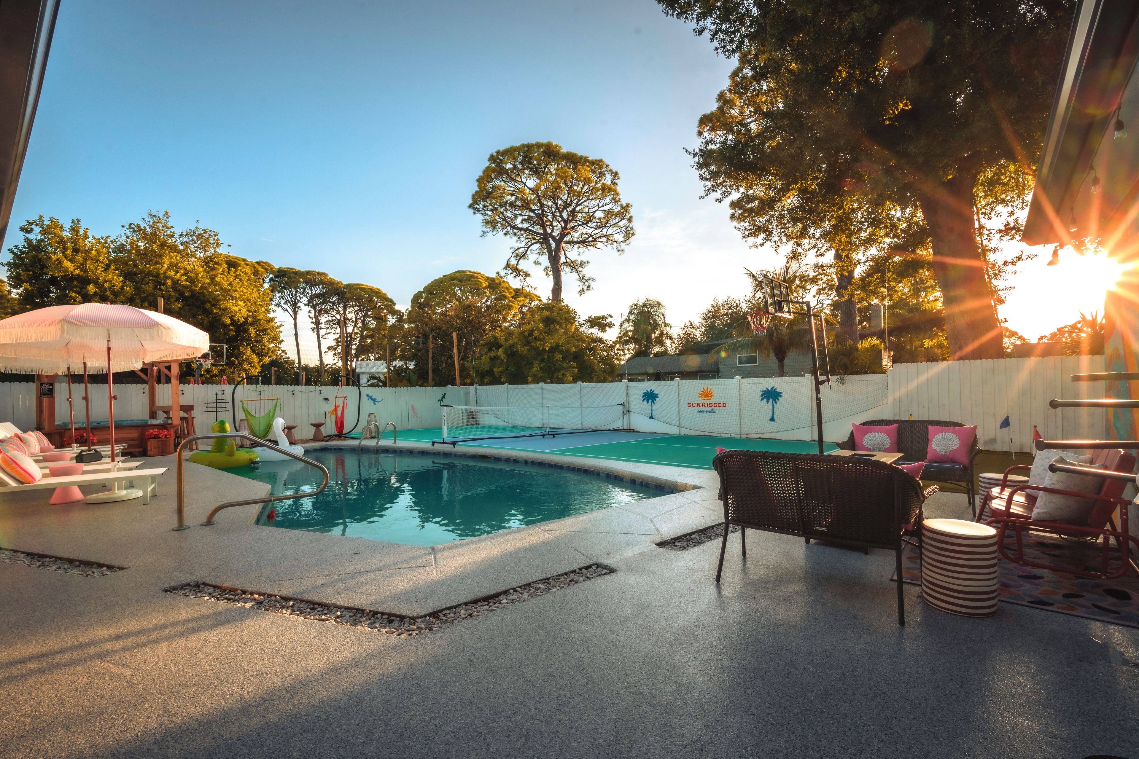 A swimming pool area with lounge chairs and a sun umbrella.