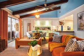 A modern living room with a sofa, coffee table, and a dining area with chairs. - Heated Pool • Hot Tub • Pickleball • Game Room (Seminole)
