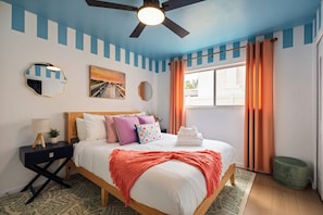 A bedroom with a bed, a nightstand, a mirror, and a ceiling fan. - Heated Pool • Hot Tub • Pickleball • Game Room (Seminole)