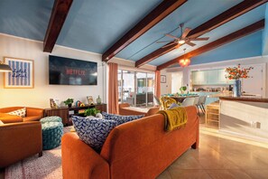 A modern living room with a sofa, a television, and a ceiling fan. - Heated Pool • Hot Tub • Pickleball • Game Room (Seminole)