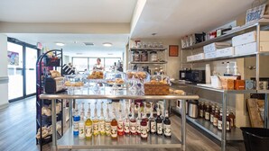 Eine Bäckerei mit Regalen voller Gläser mit Honig und anderen Gewürzen, einer Vitrine mit Gebäck und einer Theke mit Brot und Backwaren.