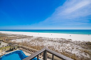 A beach view from a balcony with a pool and lounge chairs. - Phoenix Iii 3036 2 Bedroom Condo (Orange Beach)