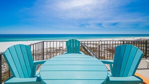 A beach view with a wooden deck and two chairs facing the ocean. - Phoenix Iii 3036 2 Bedroom Condo (Orange Beach)
