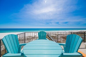 A beach view with a wooden deck and two chairs facing the ocean. - Phoenix Iii 3036 2 Bedroom Condo (Orange Beach)