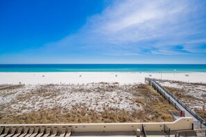 A beach with white sand, a wooden walkway, and a clear blue sky. - Phoenix Iii 3036 2 Bedroom Condo (Orange Beach)