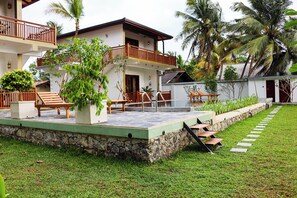A two-story building with a balcony, outdoor seating, and a stone pathway leading to the entrance. - Ever Breeze Villa (Ahangama)