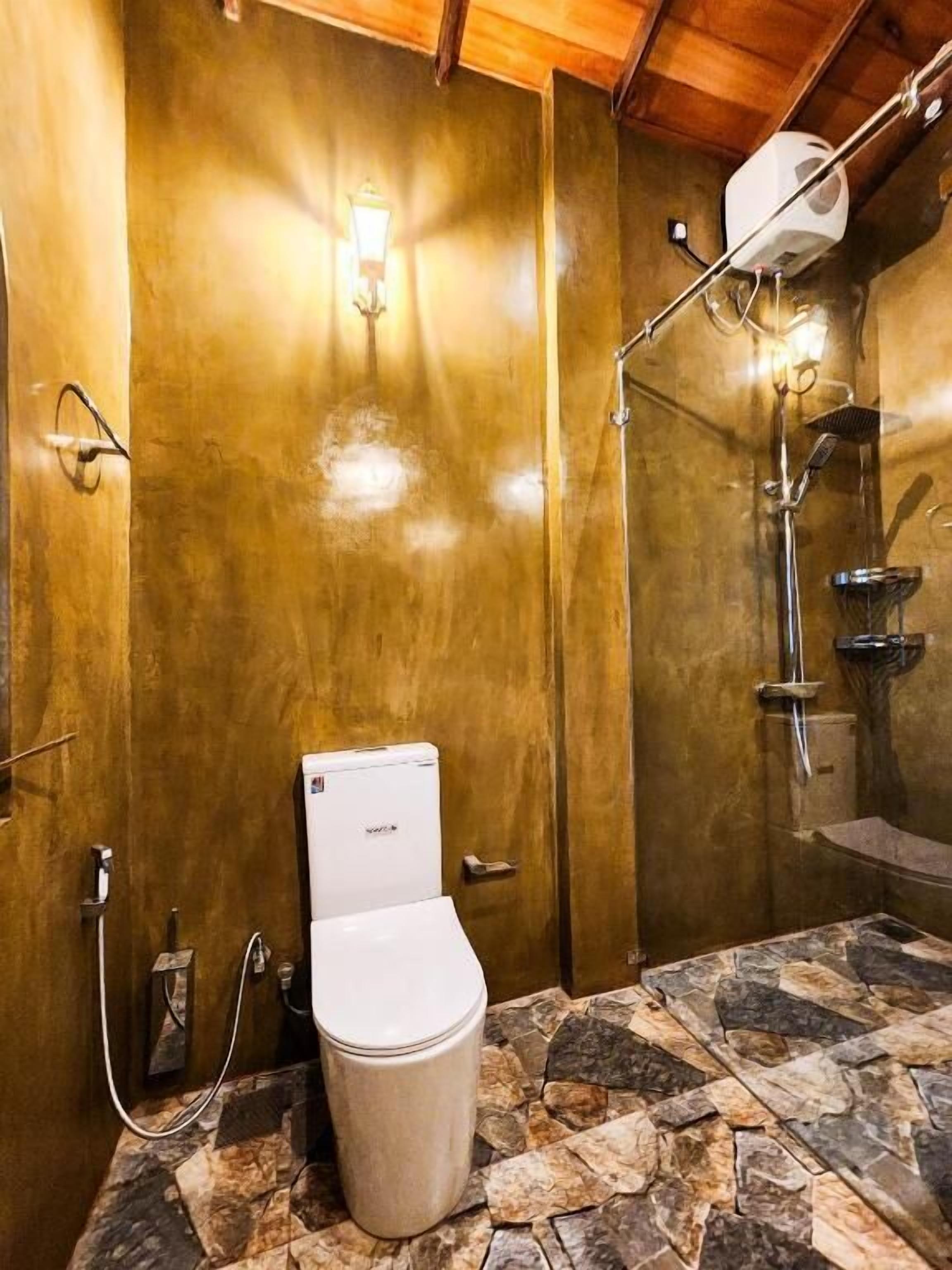 Ein Badezimmer mit Toilette, Dusche und Steinfliesen.