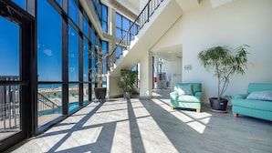 Ein großzügiger Balkon mit Blick auf den Pool, moderne Architektur und gemütliche Sitzgelegenheiten.