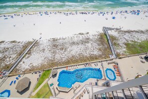 A beach with a swimming pool and a lifeguard tower. - Phoenix Iii 3128 2 Bedroom Condo (Orange Beach)