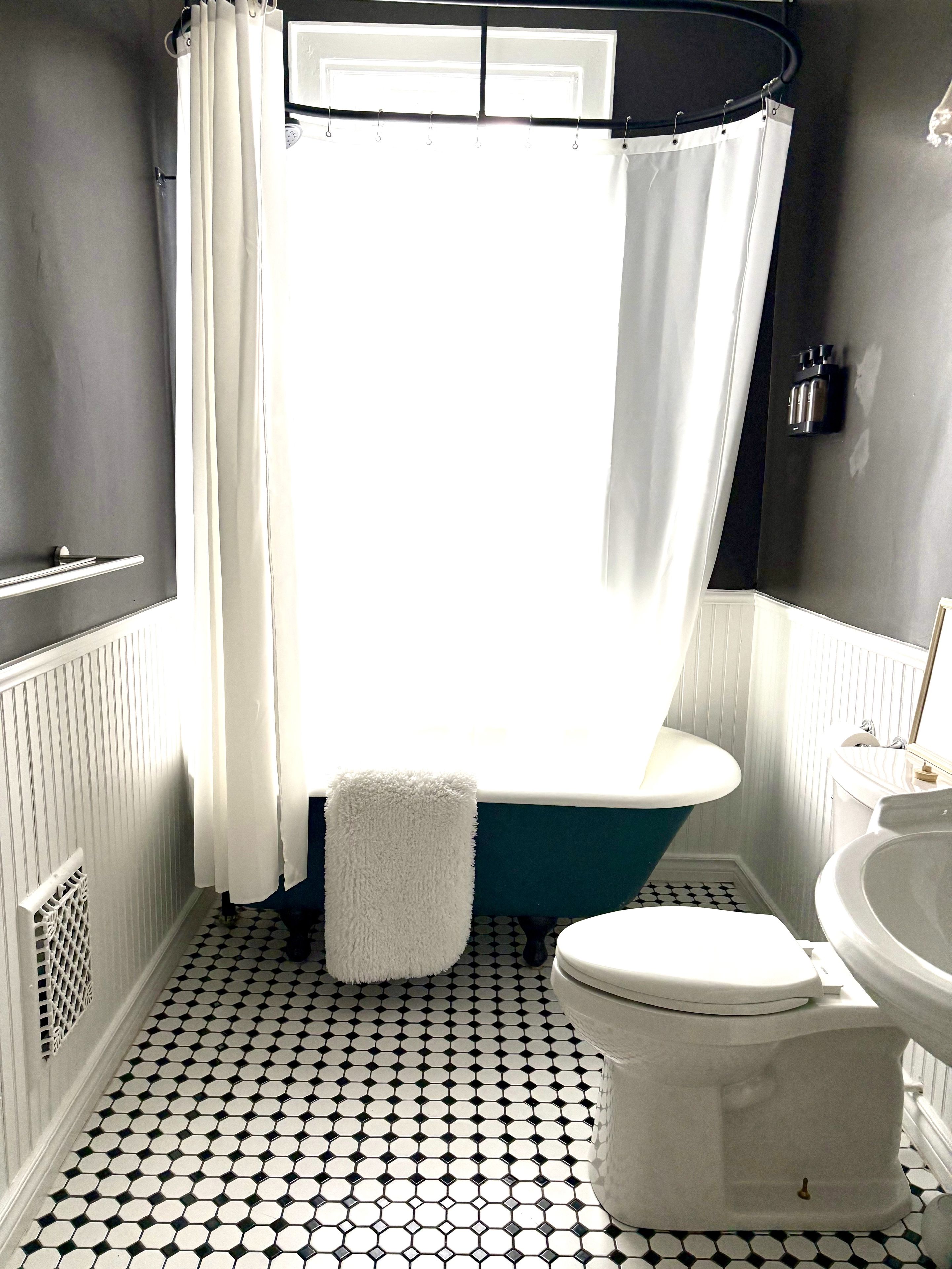 A bathroom with a bathtub, toilet, and sink.