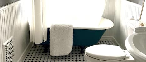 A bathroom with a bathtub, toilet, and sink.