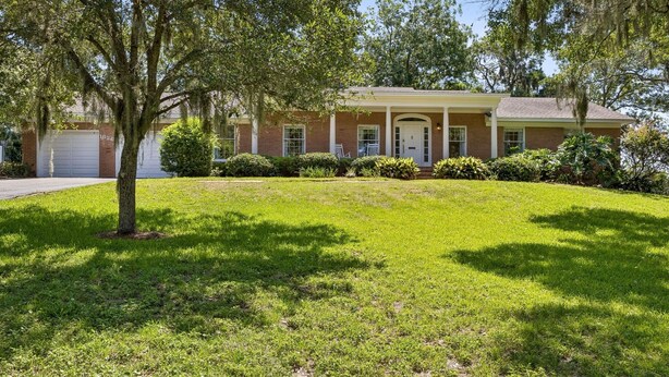 A residential house with a front porch, a garage, and a well-maintained lawn. - 1826 Highland Drive 3 Bedroom Home (Fernandina Beach)