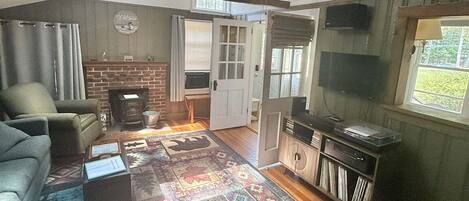 A spacious living room with a large sofa, a fireplace, a television, and a patterned rug.